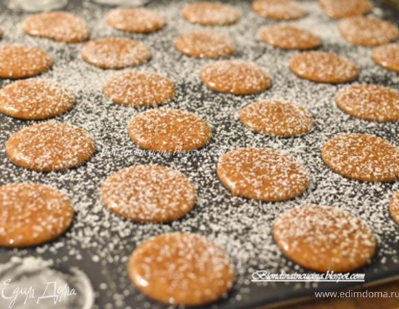 Затем взять кусочек пищевой пленки,положить сверху на macarons и придавить их слегка ладонью.Пленку убрать,посыпать их сахарной пудрой.
перекладываем силиконовый коврик на решетку,все это вместе ставим в духовку на 10-12 мин.
