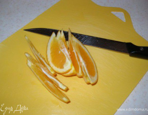 Нарезать половину апельсина тонкими дольками, а со второй половины выдавить сок и добавить к пуншу. 