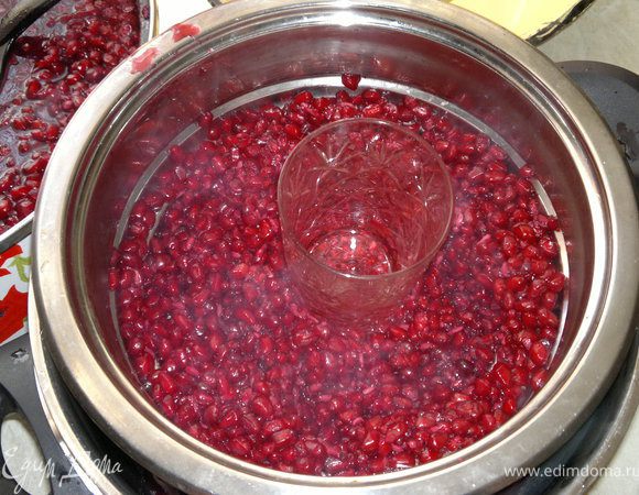 как появится сок,кладём в сторону и приступаем к работе)))  Берём другую кострюлю,кладём на неё душлаг  и выкладываем на неё немного граната(он бывает горячим,так что осторожно) и чем нибудь,чем вам удобно его выжимаем( я брала стакан),пока мы выжимаем сок он прохлаждается,можно и руками ,так даже лучше выжить