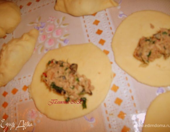 Теперь отдохнувшее тесто разделим на несколько частей и каждую часть раскатаем в круг, стаканом нужного вам диаметра вырежем кружочки, на серединку кажодго выкладываем нашу начинку