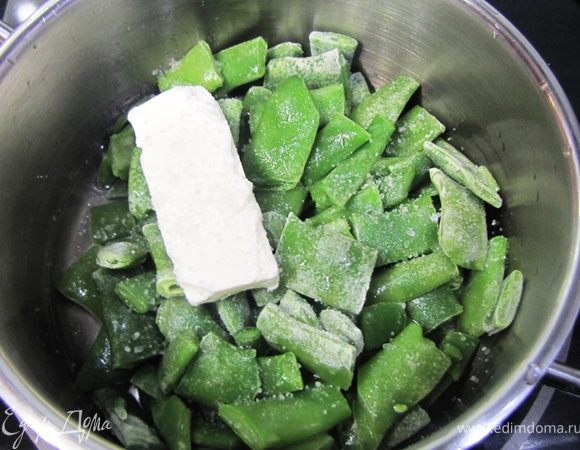 Переложите обжаренные грудки в тарелку и отставьте в сторону.
Одновременно с обжариванием грудок или позже (как вам проще), положите замороженную стручковую фасоль в сотейник.
Плесните пару столовых ложек воды и положите сливочное масло. Посолите.
Тушите под крышкой на медленном огне минут 10. Лучше, если фасоль не станет совсем мягкой.