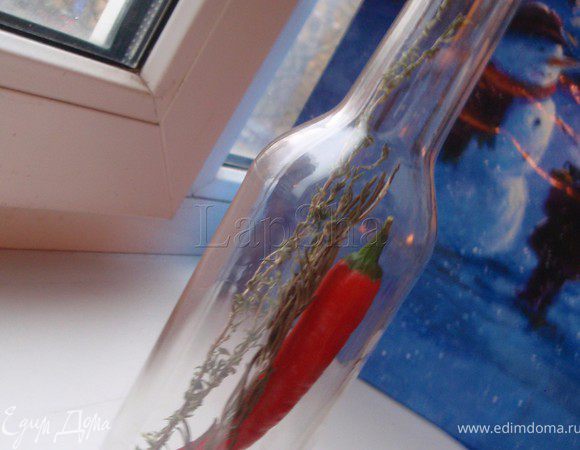 Перец чили вымыть и насухо вытереть. Поместить его в бутылку, добавить травы и перец горошком. Если вы хотите более острое масло, можно отдельно нарезать другой перец небольшими полукольцами и положить на дно бутылки. Аккуратно залить маслом и плотно закупорить пробкой. Оставить в темном прохладном месте на 10 дней.