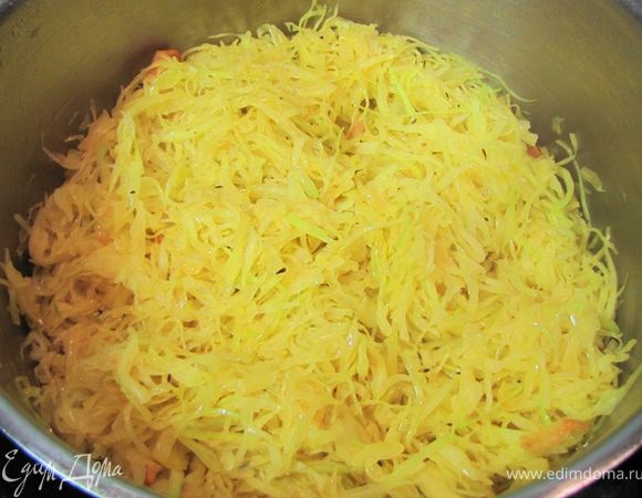 Ударьте плоской стороной ножа по зубчикам чеснока, чтобы кожица лопнула, отрежьте попки и снимите кожицу. Разрежьте вдоль пополам.
Положите в кастрюлю и жарьте секунд 15.
Положите в кастрюлю капусту и хорошенько перемешайте, чтобы вся капуста перемешалась с окрашенным маслом.