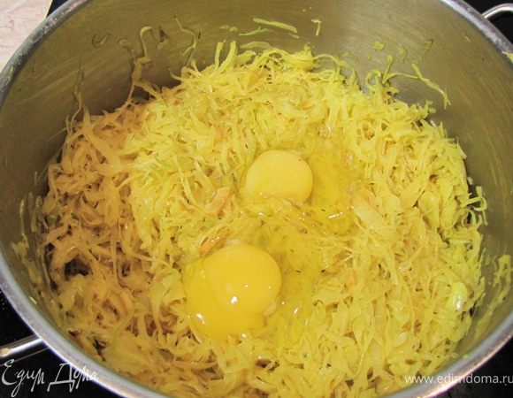 Обжаривайте капусту на среднем огне в течение 12-15 минут, периодически перемешивая. Вероятно в этот раз мне попалась более сочная капуста, да и в кастрюле ее было больше, поэтому доливать воды мне совершенно не надо было. Оставьте капусту остывать, пока подходит тесто.
Посолите капусту минут через пять после начала жарки.
В конце полейте лимонным соком и хорошенько перемешайте.
Снимите кастрюлю с огня.
Вбейте два яйца в капусту, если вы делаете не постный вариант, и хорошо перемешайте, чтобы яйца покрыли всю капусту тонким слоем.