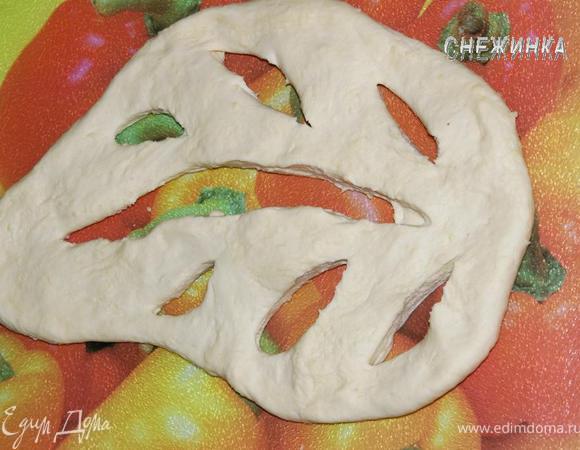 Тесто готово. Оно получается очень податливым, приятным. Теперь формируем хлеб. Раскатываем или растягиваем руками тесто в виде продолговатой лепешки. Придаем ей форму листа и делаем надрезы-отверстия в виде прожилок листа. Растягиваем тесто, чтобы образовались просветы.