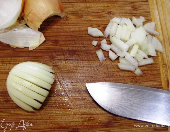 Отрежьте у луковицы стрелку и разрежьте луковицу вдоль. Снимите кожуру вместе с верхним сочным слоем лука (т.к. обычно он не очень сочный и портит вкус блюда). Попку не срезайте, она не даст половинке распасться, пока вы будете ее нарезать. Таким образом лук легче всего чистить.
Разрежьте половинку головки лука вдоль, не прорезая ее до конца, как показано на фотографии, затем нарежьте лук поперек.