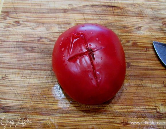 Достаньте помидоры из кипятка и обдайте их холодной водой. Разрежьте кожицу крест на крест.