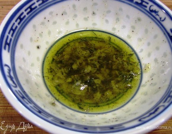 Приготовьте заправку. Для этого измельчите очень мелко два зубчика чеснока. Лично я для этого в основном использую мелкую терку. Положите туда листья тимьяна с двух веточек. Посолите заправку и поперчите ее. Учтите, что эта заправка еще не полностью готова. Большая часть ее будет использоваться при запекании. Но в готовое блюдо мы положим заправку с дополнительными ингредиентами.