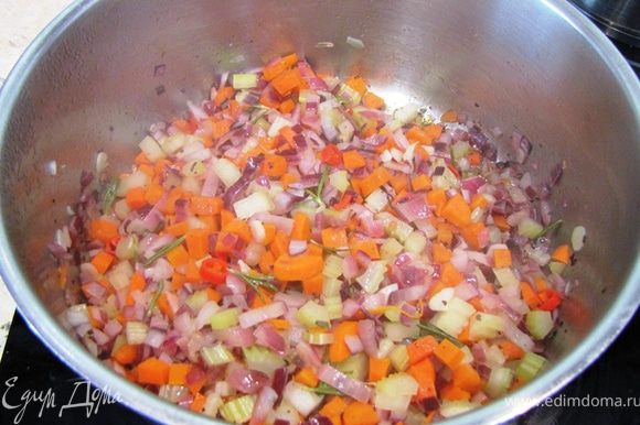 Нагрейте растительное масло в широкой неглубокой кастрюле с толстым дном. Положите туда шалфей (листья свежего или щепотку сушеного). Если у вас свежие листья шалфея, то вытащите их через полминуты. Если сушеный не вытаскивайте. Сразу положите все овощи, кроме тыквы (репчатый лук, чеснок, стеблевой сельдерей, морковь, жгучий перец). Посолите и поперчите. Положите листочки розмарина. Жарьте овощи (а точнее тушите) около 10 минут, периодически помешивая.