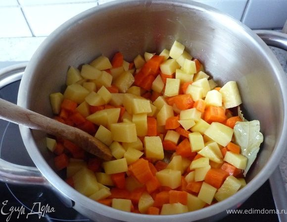 Лук почистить и мелко порезать. Картофель и морковь почистить, помыть и порезать на кусочки. Разогреть масло в кастрюле и обжарить лук, картофель, морковь. Добавить лавровый лист, влить овощной бульон, довести до кипения и под крышкой на умеренном огне тушить минут 15.