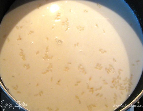 В кастрюлю с толстым дном(жаровню) выложить рис, залить горячим молоком. Оно должно покрыть рис на 5 мм выше его уровня. Посолить. Слегка перемешать ложкой. Попробывать на соль. Закрыть плотно крышкой. Довести до кипения на небольшом огне(минут 7).Уменьшить огонь до САМОГО МАЛЕНЬКОГО и пусть томиться 15-20 минут. 