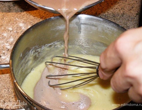 Вольем горячее молоко с шоколадом в яично-мучную смесь тонкой струйкой, постоянно помешивая.