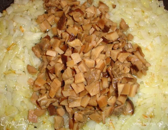 Разогреваем сковородку с маслом и отправляем туда лук. Как только он начнет золотиться, добавляем к нему грибы.