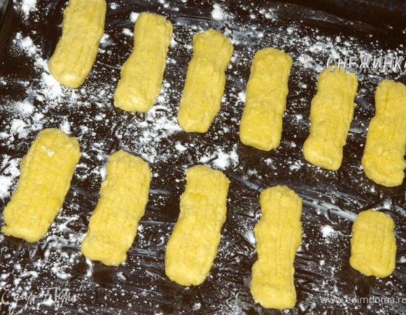 С помощью кондитерского мешка выдавить на противень ровные палочки длиной 10-12 см. У меня такого приспособления нет, я сформировала руками палочки и нарисовала полоски тупым концом ножа.