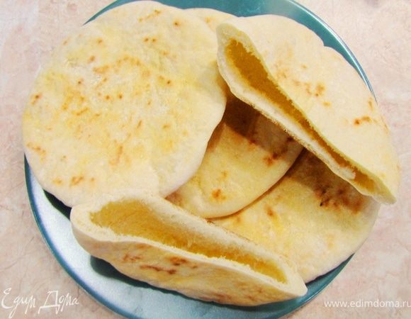 Сделайте тоже самое со всеми оставшимися 19 кусками теста. Дайте постоять 20 минут.
Разогрейте духовку до максимальной температуры.
Для приготовления пит лучше всего использовать специальные "пирожковые листы". Они тонкие и быстро прогреваются, а питы должны быть выложены на горячую поверхность, иначе внутренняя пустота не образуется.
Положите пирожковый лист или противень в духовку, предварительно смазав лист или противень растительным маслом, и нагревайте его 10 минут. Ставьте не более одного противня, иначе вы не успеете быстро положить питы на противень и температурный режим будет нарушен. Противень ставьте в самый низ, чтобы он хорошо и быстро прогревался.
Достаньте противень из духовки и обязательно закройте дверцу.
Положите аккуратно питы на противень (чем аккуратнее (без бросков) будете класть, тем "благодарнее" будет любой хлеб при выпекании).
Положите противень в духовку и выпекайте на максимальной температуре от 10 до 20 минут. От времени выпекания зависит будут ли лепешки мягкие или хрустящие (как вы любите).
Выложите готовые питы и дайте остыть до теплого состояния. Обязательно накройте полотенцем.