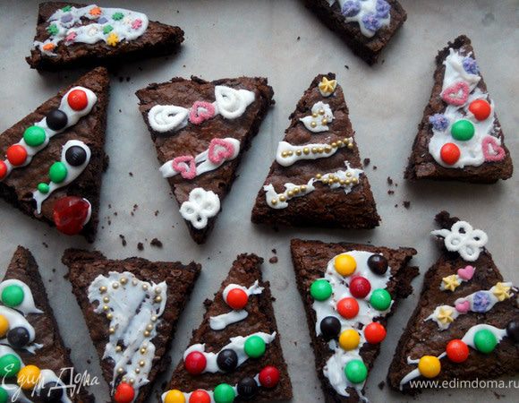 Украсить драже и посыпкой, прикрепив их к глазури/помадке. Дать полностью подсохнуть и подавать, хранить в холодильнике. ***Согласно первоисточнику, ствол дерева следовало имитировать с помощью сладкой соломки, однако покупать пачку ради украшения десятка пирожных я не стал. И зря, т.к. без "стволов" у брауни получился незавершенный вид, обычные треугольники, не более. Пришлось воспользоваться сухой пастой - пенне:) Получилось нелепо и смешно, но что уж поделать. Так что рекомендую-таки запастись соломкой:)) Во всем остальном брауни отличные! Единственное, я не рискнул добавлять орехи, чтобы поверхность не была неровной. Все же немного душевности не помешает, просто хорошо измельчите орехи и/или вяленую клюкву (в этом случае количество муки, скорее всего, уменьшится) - будет еще лучше!***