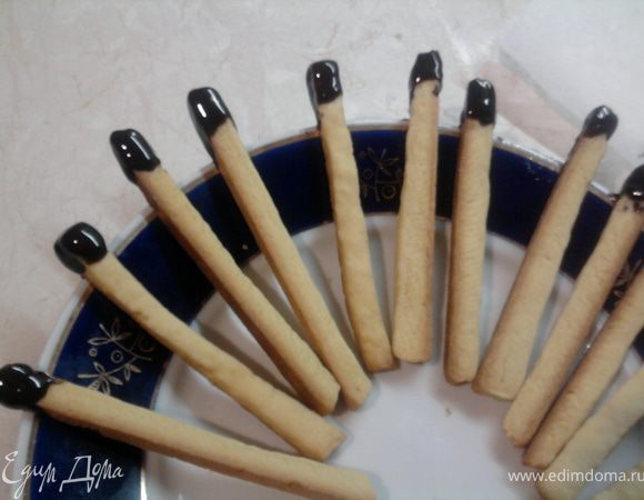 Пока печенья остывают, растопить шоколад и дать ему немного остыть, чтоб он не стекал со "спичек". Краешек печенья окунуть в шоколад и положить так, чтоб шоколад застыл.