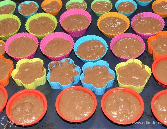 Смазать формочки маслом (силиконовые не смазывать) и наполнить на две трети тестом.