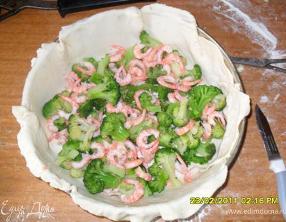 400 гр брокколи отвариваем 2-3 мин в подсоленной воде, выкладываем, чтобы стекла вода, разрезаем на половинки, укладываем на тесто. Креветки мелкие отвариваем (я брала 1 кг), очищаем, выкладываем на брокколи.