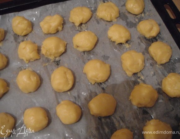 Застелить противень бумагой для выпечки, смазать маслом и выложить маленькие шарики из теста. Тесто будет липнуть к рукам и по тому смачивайте их водой.