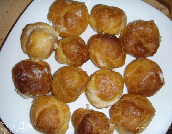 Обычно торт собирают в конус из ватмана, обмакивая эклеры в карамель и скрепляя, мотом переворачивают. Я сделала по другому: Выложила дно блюда плотно эклерами.