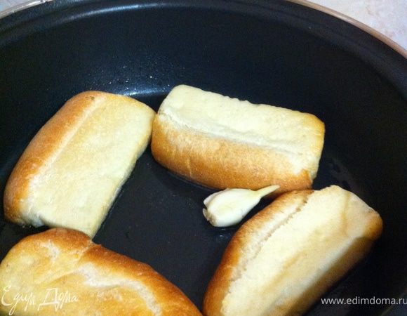 параллельно приготовим чесночные гренки: прогреть в сковороде оливковое масло с раздавленной плоской стороной ножа долькой чеснока. Хлебцы разрезать пополам и обжарить на чесночном масле с двух сторон до золотисио-румяной корочки)