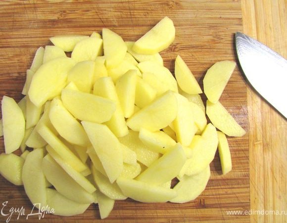 Чистим картофель. Если клубни небольшие разрезаем вдоль пополам и затем поперек по пол сантиметра толщиной.