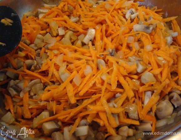 Пассируем лук. Добавляем грибы. Когда они почти готовы, добавляем натертую на крупной терке морковь и даем время потомиться.