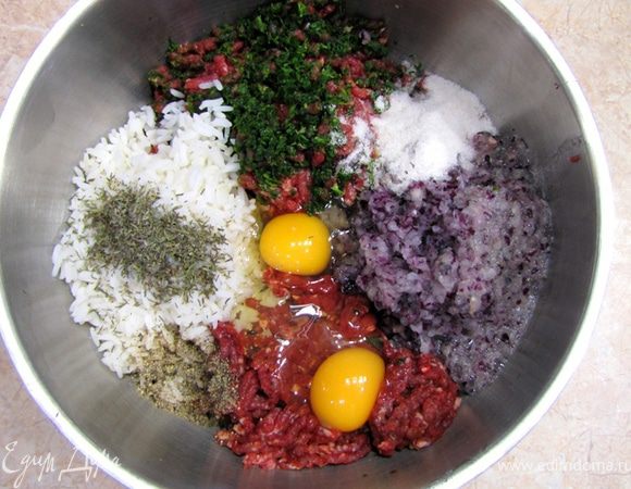 Перемелите мясо в мясорубке. Зелень перемелите между кусками мяса, чтобы части зелени не остались в мясорубке. Туда же добавьте репчатый лук.
Добавьте рис, два яйца, соль, перец, тимьян. Смешайте фарш.