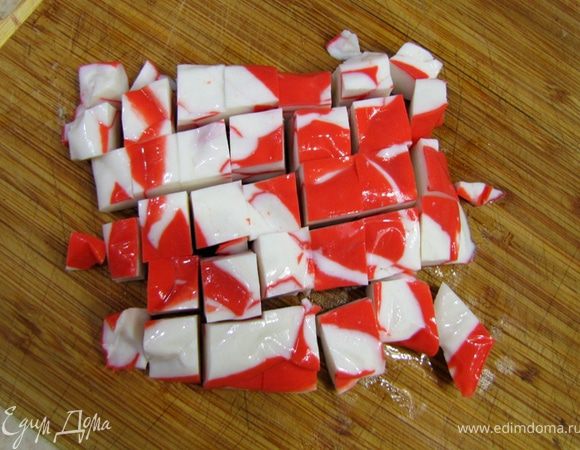 Вытащите крабовое мясо и порежьте его, как показано на фотографии - крупно. В процессе перемешивания мясо еще распадется и будет великолепным. Если используете крабовые палочки - режьте их по одному сантиметру.