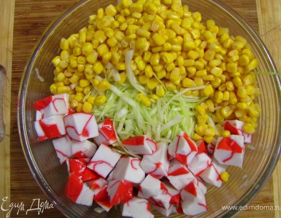 Откройте банку с кукурузой. Сок из банки выпейте   , кукурузу вместе с крабовым мясом положите в емкость для салата.