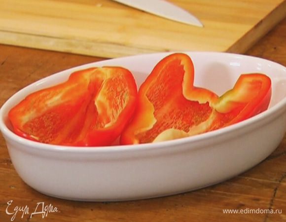 Перец разрезать вдоль пополам и, удалив плодоножку и перепонки, поместить в небольшую форму для выпечки.