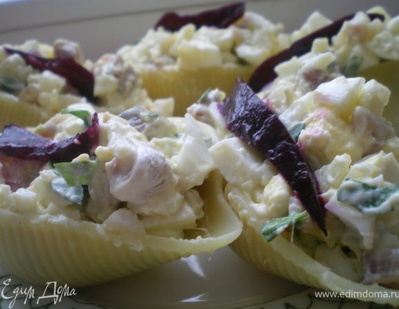 Конкильони отварить до готовности. Сельдь и картофель нарезать кубиками, яйца и зелень нарубить. Салат заправить майонезом. Нафаршировать конкильони салатом. По желанию украсить свеклой.