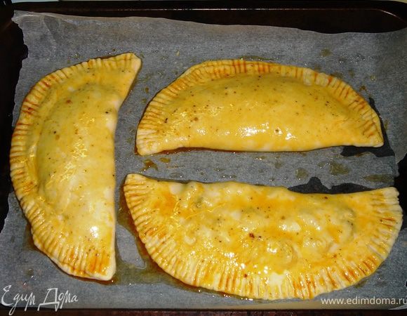 По краю чебурека при помощи вилки сделать окантовку, прижимая вилку к тесту.
Сверху чебуреки смазать зазарочкой, оставшейся после жарки фарша.