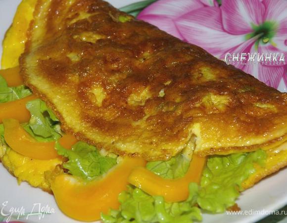 Готовый омлет сворачиваем пополам, вложив в него листья салата и перец, выкладываем на тарелку.