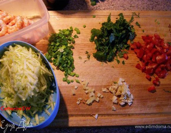 Мелко порежем лук, порубим чеснок, мелко порежем корень имбиря, кабачок очистим и потрем на крупной терке, болгарский перец порежем кубиком, кинзу порубим, яйца взобьем с солью вилкой, креветки разморозим и очистим от панциря