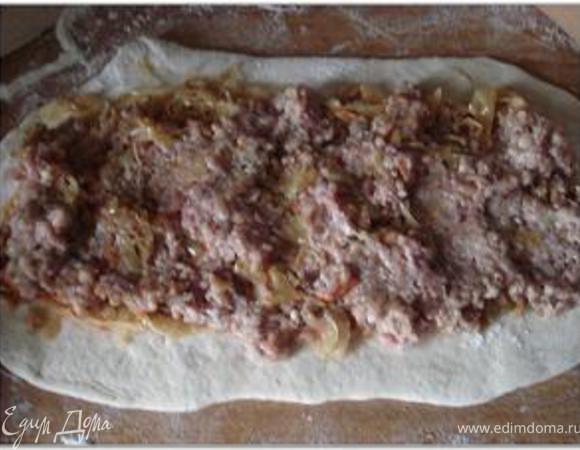 Выложить на тесто начинку вдоль. Сначала слой капусты, а затем слой фарша. (В мясной фарш можно по желанию добавить порубленное яйцо и обжаренный лук, а можно яйца с луком сделать 3-м слоем начинки).