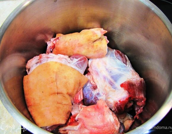 Промойте мясо. Вы должны очень хорошо отмыть кожу, т.к. она пойдет в сам холодец. Лично я отмывал свиные ножки с помощью металлической щетки. В итоге она стала очень чистой без серых пятен. Сложите в кастрюлю мясо.