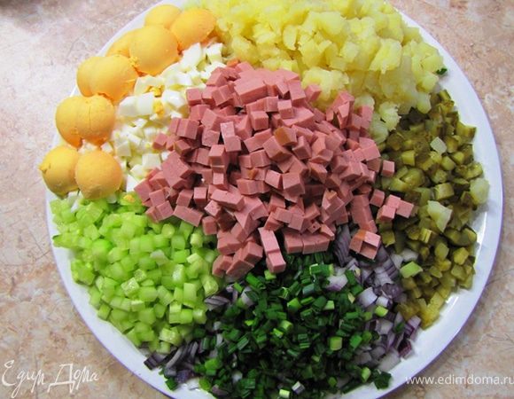 Нарежьте все ингредиенты на одинаковые кусочки, включая репчатый лук. Огурец лучше всего почистить. Яйца можете нарезать без желтков, а затем раскрошить желтки в салат. Порежьте мелко петрушку.