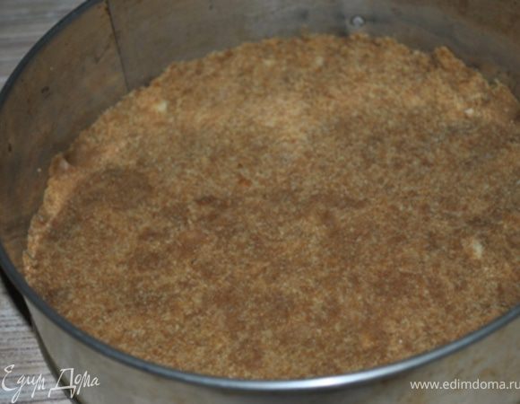 Печенье размолоть, смешать с растопленным маслом. Полученную смесь выложить на дно формы 22 см. Выпекать при 180 гр. 10 минут.