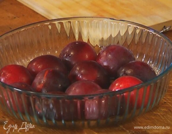 Сливы разрезать и, удалив косточки, выложить в жаропрочную форму срезами вниз.