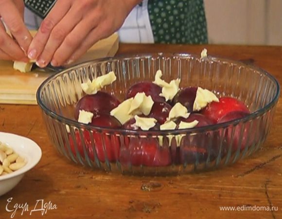 Порезать 50 г сливочного масла кусочками и выложить сверху на сливы.