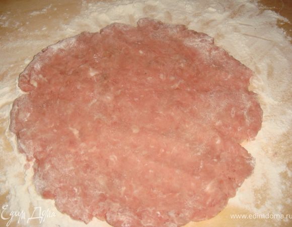 На доске присыпанной мукой мы обваливаем колобок из фарша и пальцами разминая делаем лепешку размером с  тарелку.