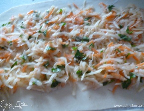 Тесто делим пополам и раскатываем тонко(как на пельмени,у меня получился пласт примерно 30на35см.)Делим вдоль на две части,выкладываем начинку.