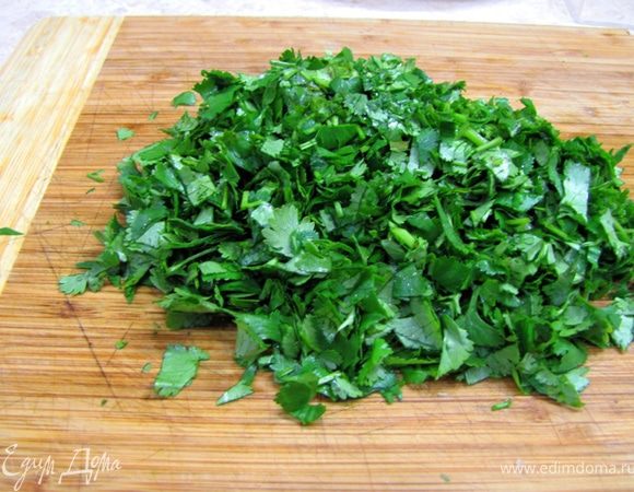 Возьмите кинзу и петрушку, оторвите или отрежьте стебли. Порубите зелень довольно мелко.