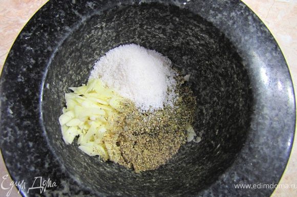 Готовим маринад для баранины: три зубчика нарубите. Чеснок, крупную соль, сухие травы и свежемолотый черный перец положите в ступку.