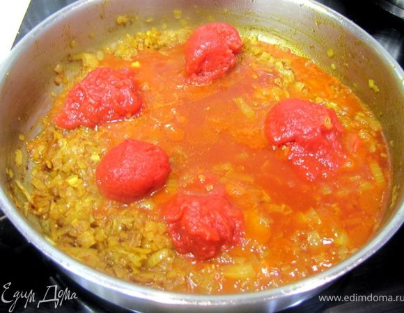 Положите в сковороду помидоры вместе с соком из банки. Слегка разомните вилкой помидоры.