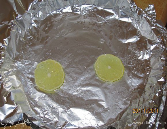 Фольгой застилаем форму, смазываем маслом и кладём два кусочка лимона.