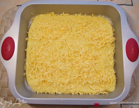 Выложить поленту в форму для запекания, смазанную маслом. Желательно использовать большую неглубокую форму, чтобы толщина поленты была не более 1-2 см. Если взять глубокую форму и полента будет толще, чем 1-2 см,то можно будет после приготовления её разрезать. Сверху посыпать тёртым сыром. Дать постоять. 