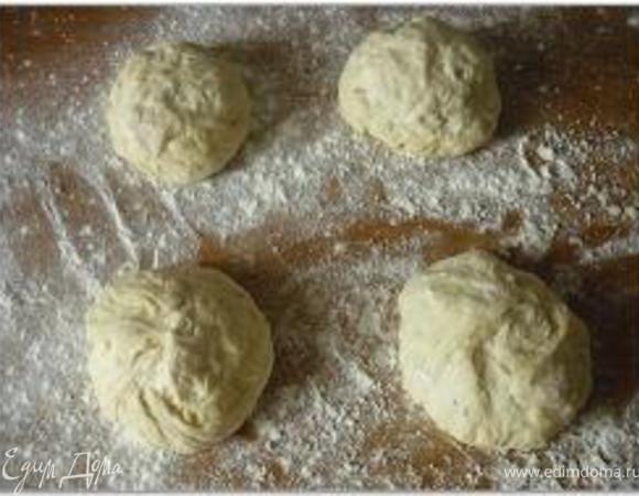 Выложить тесто на присыпанный мукой стол и разделить на 4 части. Сформировать из каждого куска шар, присыпать мукой, накрыть плёнкой или полотенцем и оставить на 20-30 минут (на время нагревания духовки).